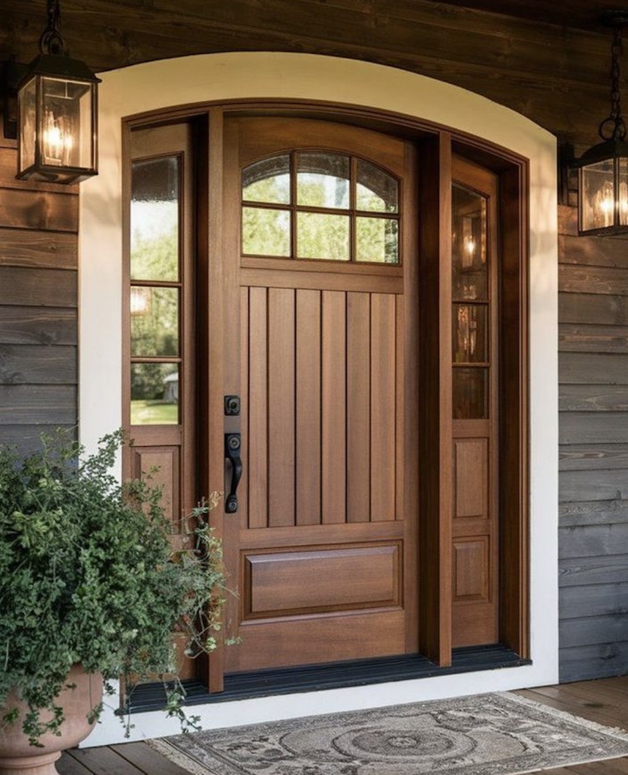 Finished wood entry door framed by crisp white trim and deep charcoal siding